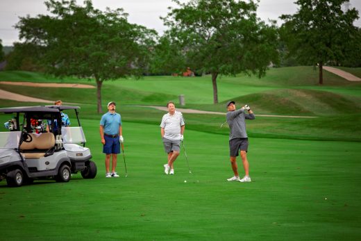 Golf team next to their golf cart