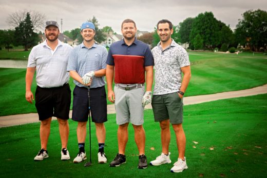 four male golfers standing