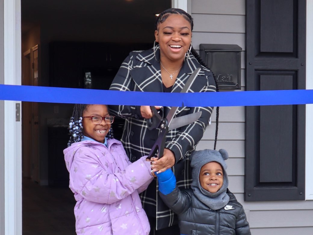 TiAnna and her two kids cutting ribbon at home dedication
