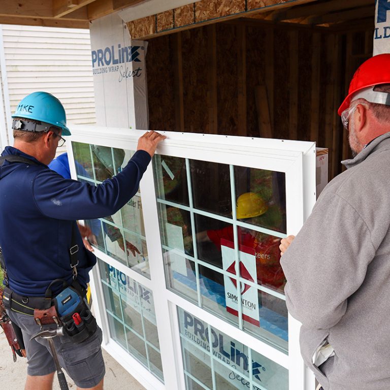Two men installing a window