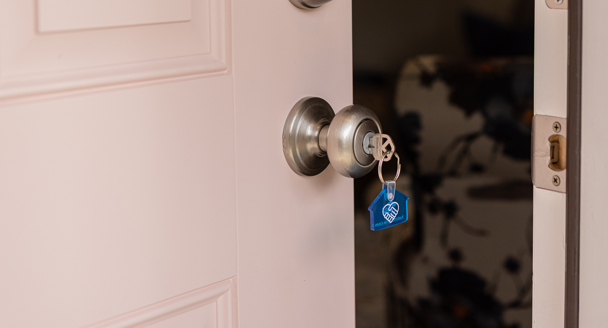 Pink door with Habitat keychain in lock