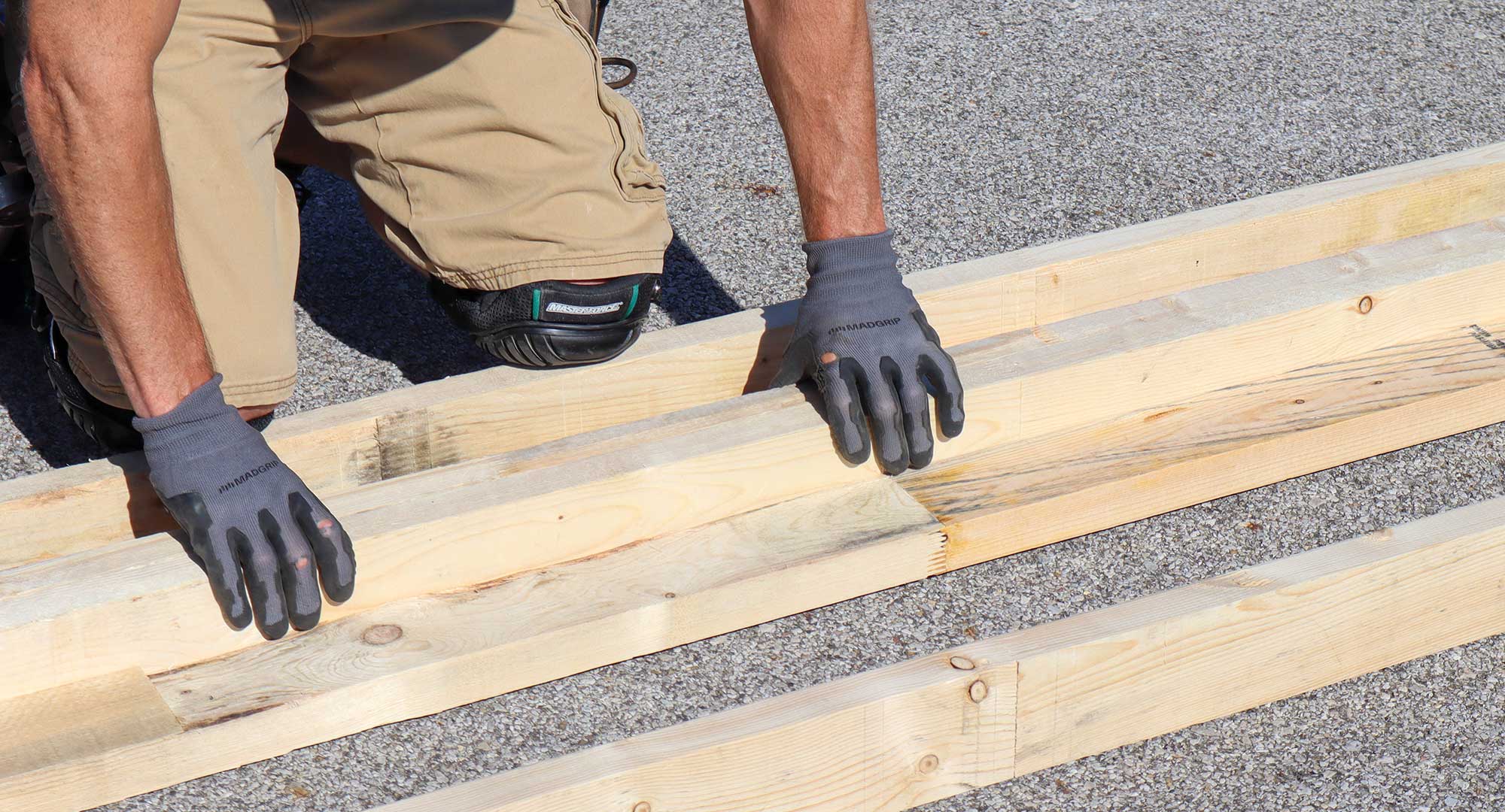 Hands with work gloves moving wood