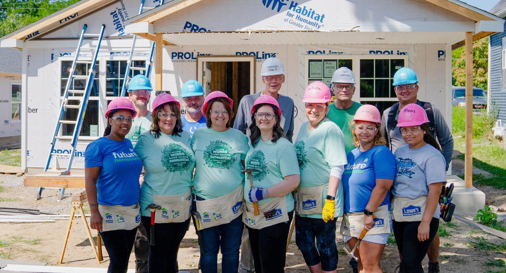 Group of Women Build volunteers with Habitat crew leads on construction site