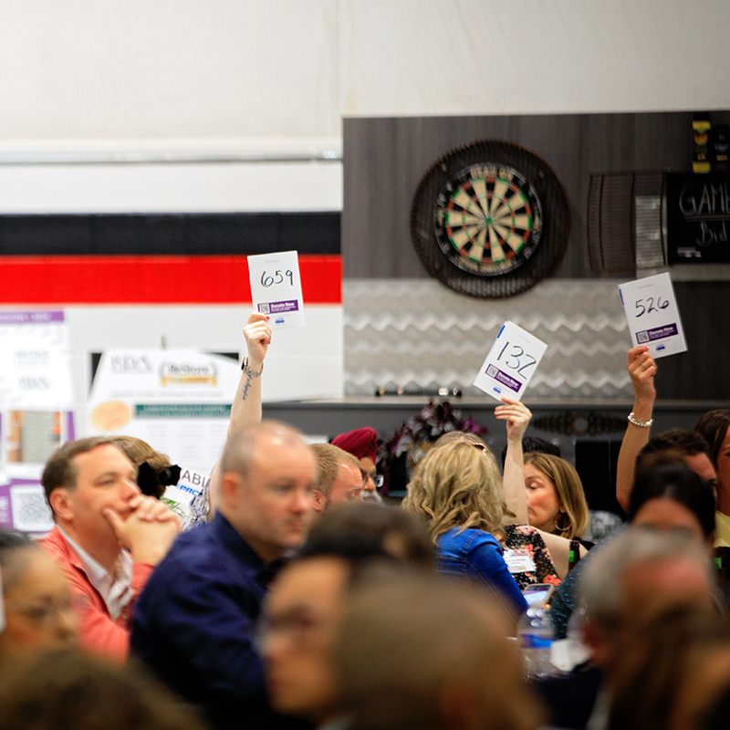 Crowd holding up bidder numbers