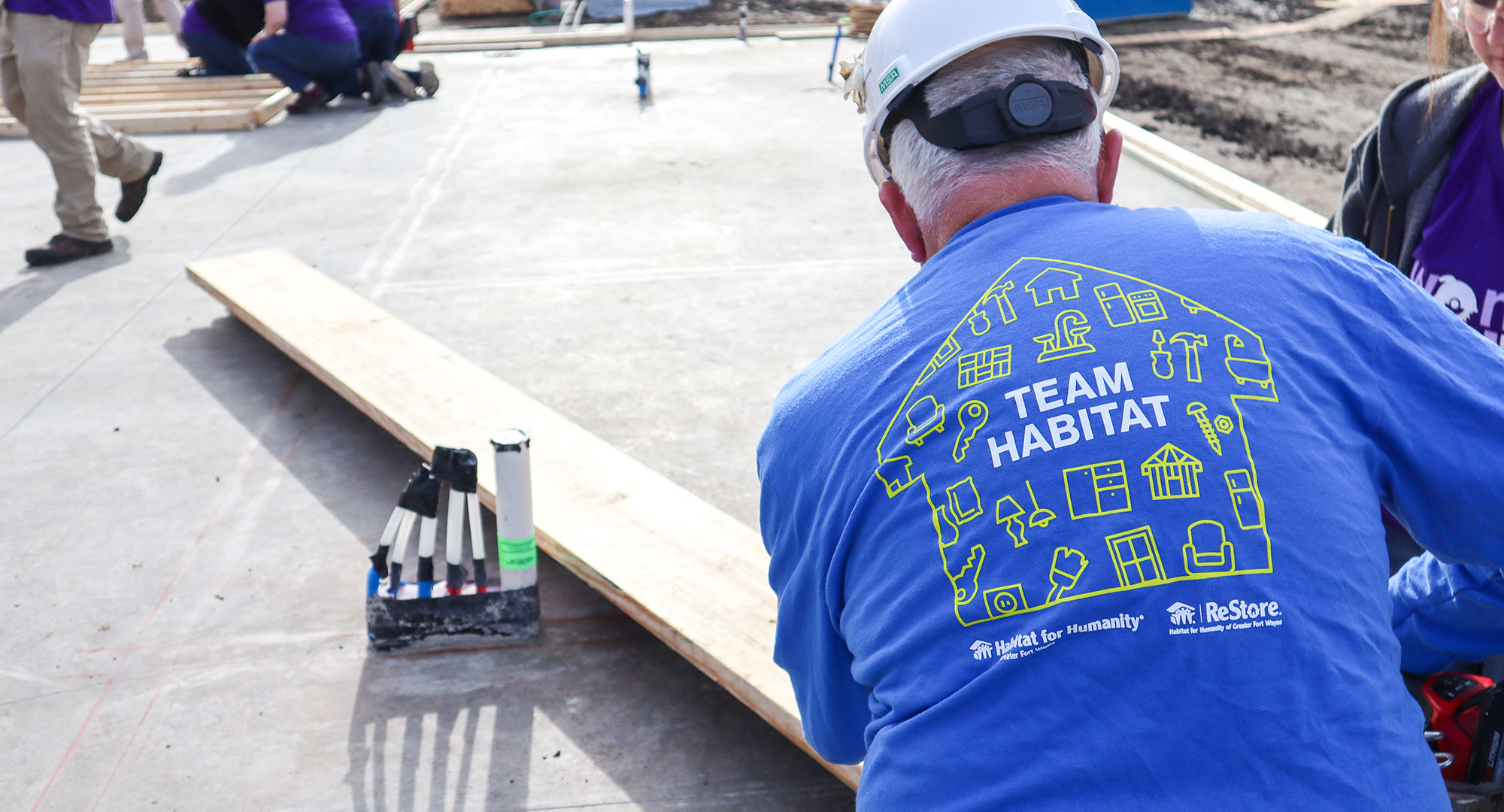 Back of man's shirt reads "Team Habitat"